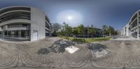 a fish eye view of some building and a park area with some skate boards and trees