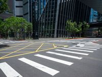 crosswalk at the corner of a street with buildings in the background with yellow lines