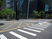 crosswalk at the corner of a street with buildings in the background with yellow lines