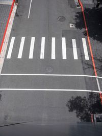 an empty street is dotted with red tape to make a road cross the middle of it