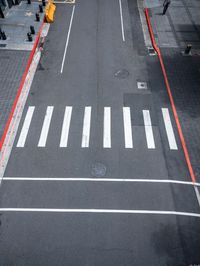 an empty street is dotted with red tape to make a road cross the middle of it