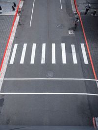 an empty street is dotted with red tape to make a road cross the middle of it