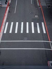 an empty street is dotted with red tape to make a road cross the middle of it