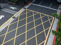 the parking lot is marked with yellow lines on the pavement at the crosswalks