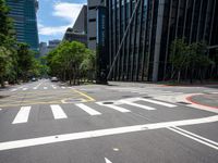 empty city street with multiple lanes on both sides of the street and lots of green trees in the middle of the road