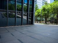 an empty city plaza with trees and benches outside the building that houses an office building