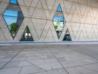 the walkway is surrounded by glass windows in the building and with small triangles around it