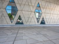 the walkway is surrounded by glass windows in the building and with small triangles around it