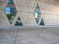 the walkway is surrounded by glass windows in the building and with small triangles around it