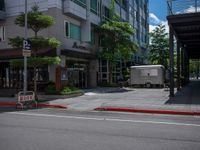 a street scene in the daytime with an old fashioned trailer parked at an empty curb