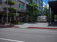 a street scene in the daytime with an old fashioned trailer parked at an empty curb