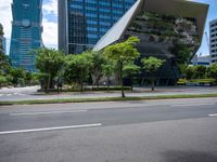 a empty street and two tall buildings next to it with trees lining the sides of it