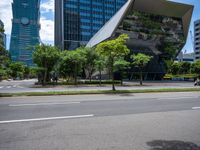 a empty street and two tall buildings next to it with trees lining the sides of it