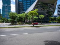 a empty street and two tall buildings next to it with trees lining the sides of it