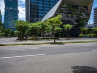 a empty street and two tall buildings next to it with trees lining the sides of it