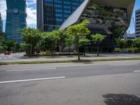 a empty street and two tall buildings next to it with trees lining the sides of it