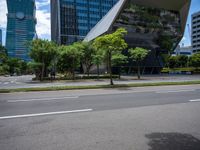 a empty street and two tall buildings next to it with trees lining the sides of it