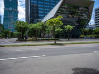 a empty street and two tall buildings next to it with trees lining the sides of it