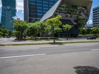 a empty street and two tall buildings next to it with trees lining the sides of it