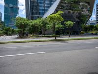 a empty street and two tall buildings next to it with trees lining the sides of it