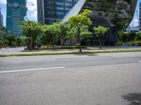 a empty street and two tall buildings next to it with trees lining the sides of it