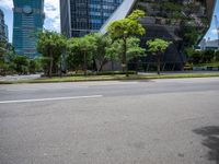 a empty street and two tall buildings next to it with trees lining the sides of it