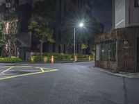 night time picture of parking lot with parking meter in the background on a street corner