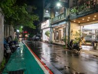 motorcyclists and pedestrians on a city street during the rainy night time and rain