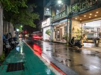 motorcyclists and pedestrians on a city street during the rainy night time and rain