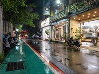 motorcyclists and pedestrians on a city street during the rainy night time and rain