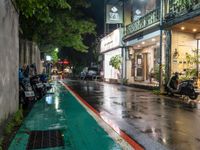 motorcyclists and pedestrians on a city street during the rainy night time and rain