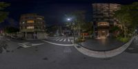 360 - view of city streets at night with lights on them, and people walking and bicycles parked in the foreground