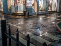 a street scene with a manhole and the pedestrian crossing crosswalk at night time