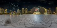 the view of the city at night from a mirror in the courtyard of an artistic structure