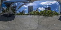 a city skyline and skyscrapers are seen through two circular mirrors in a park area