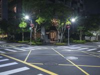 an empty crosswalk in a street at night with multiple lights on the street below it