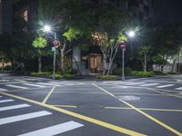 an empty crosswalk in a street at night with multiple lights on the street below it