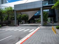 a pedestrian crossing over a red painted line on the road near buildings and trees in the background