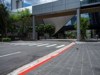 a pedestrian crossing over a red painted line on the road near buildings and trees in the background