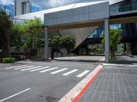 a pedestrian crossing over a red painted line on the road near buildings and trees in the background