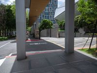 a photo of an outside walkway with street signs and buildings in the background the sign reads