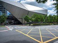 two yellow lines are seen in a parking spot in front of an opera theatre building