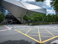 two yellow lines are seen in a parking spot in front of an opera theatre building