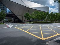 two yellow lines are seen in a parking spot in front of an opera theatre building