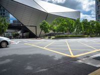 two yellow lines are seen in a parking spot in front of an opera theatre building