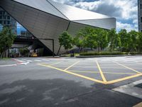 two yellow lines are seen in a parking spot in front of an opera theatre building