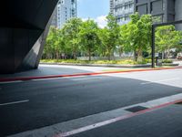 street with trees on both sides and a road below it that has red lines painted