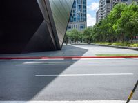 a yellow traffic light on top of a street next to tall buildings, near some grass, and red curb