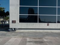 an empty parking lot and a sign near a building with many windows on it and a fire hydrant sitting outside