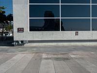 an empty parking lot and a sign near a building with many windows on it and a fire hydrant sitting outside